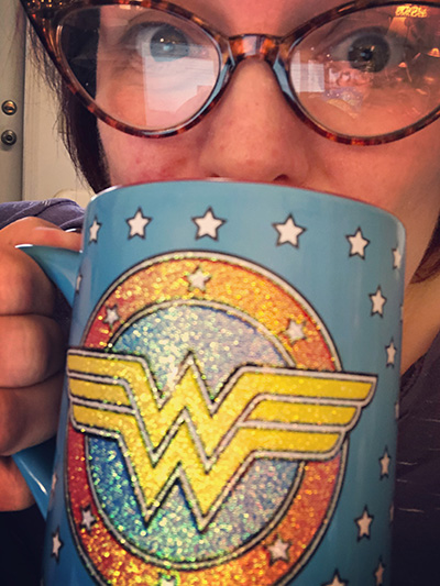 Michelle bebiendo de una taza de la Mujer Maravilla
